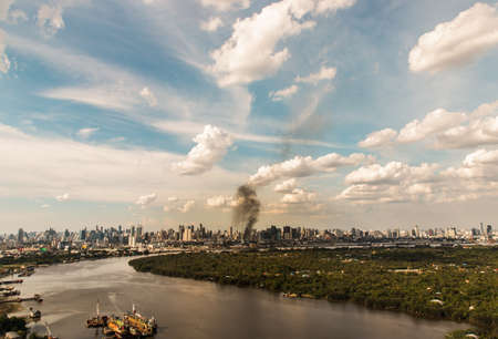 Bangkok, Thailand - 04 Jul, 2021 : Plume of smoke clouds from burnt building on fire at some area in the city. Fire disaster accident, Selective focus.のeditorial素材