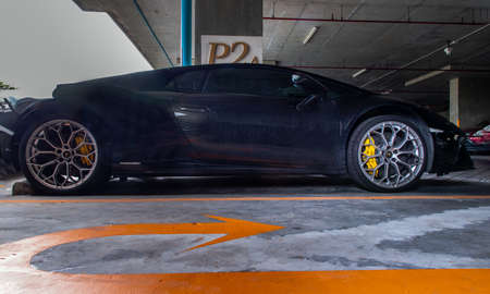 Bangkok, Thailand - 26 Jul 2021 : Side view of Wheel of Black Lamborghini Sports Car parked in the parking lot. Lamborghini is an Italian sports car. Selective focus.のeditorial素材