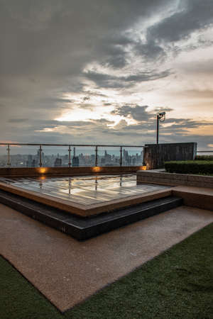 Bangkok, Thailand - 30 Jul 2021 : Rooftop terrace with overlooking the urban view While it's raining at sunset. Copy space, Selective focus.のeditorial素材