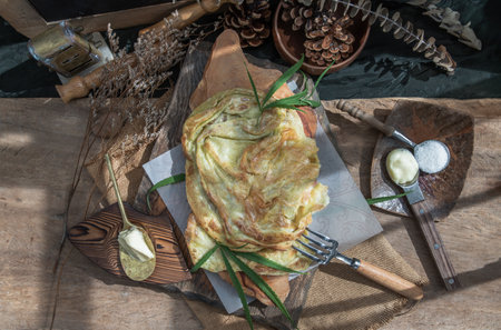 Homemade sweet frying roti (Cannabis Pancake) with cannabis and marijuana leaf on old wooden table. Concept of dessert with cannabis herb, Treatment of medical marijuana for use in food, Top view, Selective focus.の写真素材