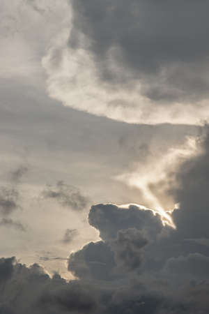 The sun shines through the clouds in the sunset sky with dramatic light. The shape of the clouds evokes imagination and creativity. They can be used as wallpapers that look amazing. Copy space, Selective focus.の写真素材
