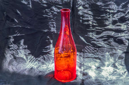 Colored transparent green glass cup and green glass bottle for water drinking and surface reflections on a black background. Copy space, Selective focus.の写真素材