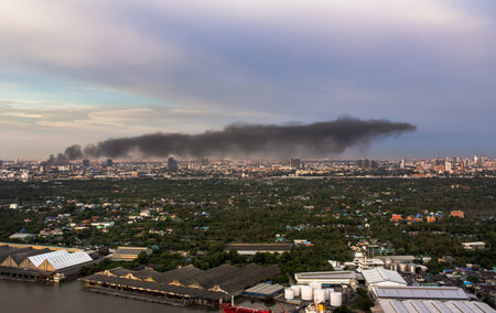 Bangkok, Thailand - 19 Aug, 2021 : Plume of smoke clouds from Burnt industrial or office building on fire at some area in the city. Fire disaster accident, Selective focus.のeditorial素材