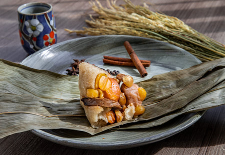 Chinese rice dumplings (Zongzi) shaped pyramidal wrapped by leaves ingredients on bowl chinese style...