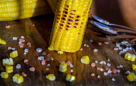 Grilled corn on the cob  on rustic wooden board over brown leather background.  Ideas for barbecue and grill parties, Barbecue concept.の写真素材