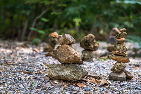 Balanced stone tower on walkway up the mountain with green plants in the background. Copy space, Selective focus.の写真素材