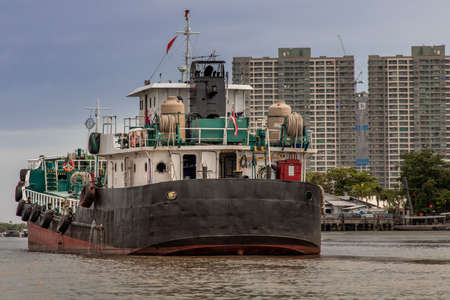 Bangkok, Thailand - 10 Jul 2020 : A cargo ship parked in the middle of the Chao Phraya River with sky at the background.のeditorial素材