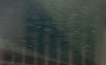 Rain drops falling in the swimming pool. Water surface for background and abstract.の写真素材