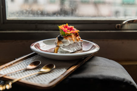 Yuzu blueberry tart with blueberrie and beautiiful indian blanket flower served on white plate with two Spoons. French dessert. Selective focus.の写真素材