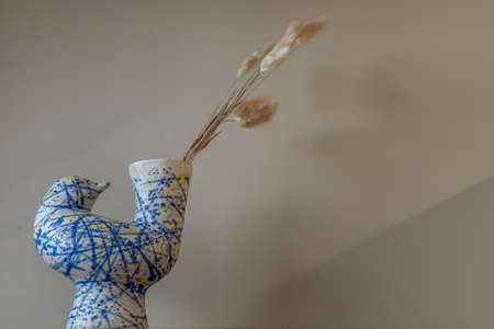 Dried flowers in beautiful ceramic blue vase on wall of living room. Home decor. Space for text. Selective focus.の写真素材