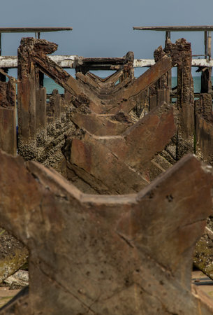 Looking out at Broken old structure remains of pier in the sea. Small wave crashing into the...