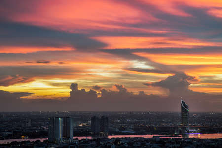 Bangkok, thailand -Sep 17, 2021 : Fantastic colorful sunset sky over the bangkok city skyscrapers and the Bridge crosses the Chao Phraya river with bright glowing lights at dusk give the city a modern style. Copy space, Selective focus.のeditorial素材