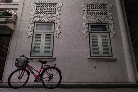 Bangkok, Thailand - 16 Aug 2019 : A red bicycle parked beside the wall at Wat Bhoman Khunaram (Bhoman Khunaram Temple).のeditorial素材