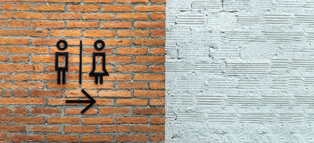 Female / Male restroom. Sex symbol on red brick wall and white brick as background. Toilet icon, Restroom Concept, Selective focus.の写真素材
