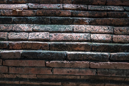 Close-up of Cracked concrete vintage red brick wall background. Archaeological area. Pattern on the wall with space for text, No focus, specifically.のeditorial素材