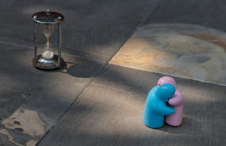 Blue and pink ceramic couple dolls hug with each other on stone background. Concept for anniversary, Wedding and eternal love concept, Romance wedding or Valentineâs day.の写真素材