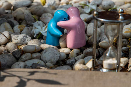 Blue and pink ceramic couple dolls hug with each other on stone background. Concept for anniversary, Wedding and eternal love concept, Romance wedding or Valentineâs day.の写真素材