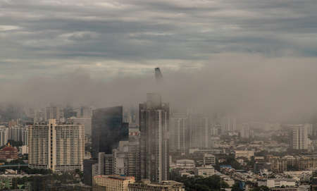 Bangkok, thailand -Aug 29, 2021 : An impressive aerial top view of skyscrapers at downtown Bangkok city in morning fog. No focus, specifically.の写真素材