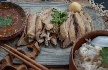 Close-up of Asian food style marinated steamed chicken (Betong Chickken) with Rice and sauce on ceramic plate.の写真素材
