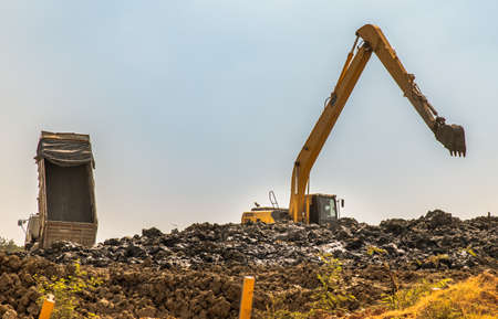 Excavator on earthworks at construction site at afternoon. Backhoe on earthmoving and foundation work. Heavy machinery and equipment. Selective focus.のeditorial素材
