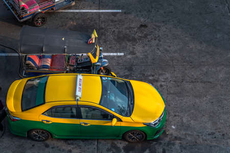 Bangkok, Thailand - Dec 22, 2019 : Yellow green Taxi car and Blue Tuk Tuk parked for filling LPG  (Liquefied Petroleum Gas) gas at gas station. Selective focus.のeditorial素材