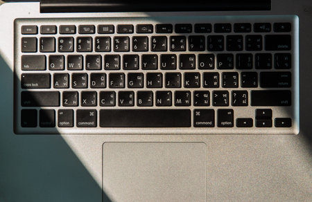 Close-up detail view of a laptop keyboard on the keys with high contrast and shallow depth of field....