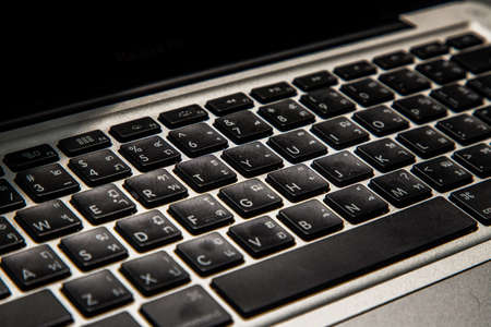 Close-up detail view of a laptop keyboard on the keys with high contrast and shallow depth of field. Computer keyboard, Selective focus.の写真素材