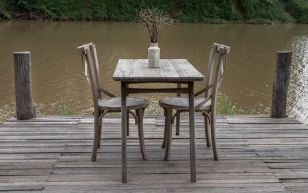 Relaxing corner beside the river and dried flowers in white vase for decoration purpose on old...