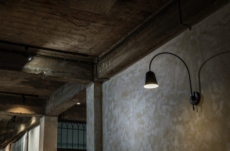 Black lamp on grunge concrete cement wall in loft style. Selective focus.
