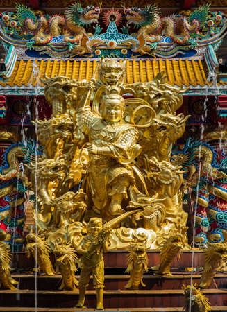 Chonburi, Thailand - 05 Feb 2022 : Nezha guardian deity gold statue and Dragons at Wihan Thep Sathit Phra Kitthi Chalerm Shrine (Nacha Sa Thai Chue Shrine or Naja Shrine). Selective focus.のeditorial素材