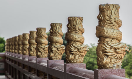Chonburi, Thailand - 05 Feb 2022 : Column pillar at oriental golden hand rail on corridor in Chinese-style temple. Emboss gold pillars stucco, Selective focus.のeditorial素材