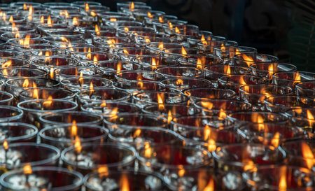 Detail of Many red votive candles light inside Chinese temple. Rows of Votive Candles in Glass with shallow depth of field, Blurred of candles, Red Candle is kindle a fire in glass, Abstract Meaning of Religion. Selective Focus.の写真素材
