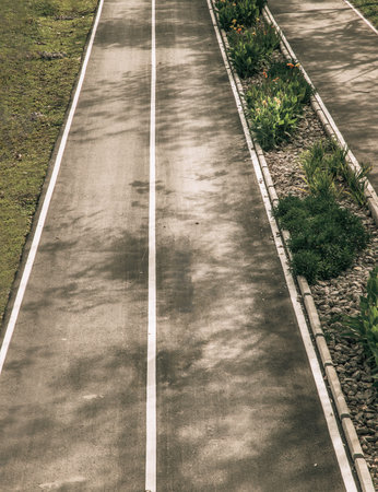 Top view of empty road texture with median strip in the middle surrounded green grass. Selective...