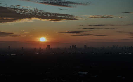 Gorgeous scenic of the sunrise sky with cloud on the orange sky over large metropolitan city in Bangkok. Travel attraction in Thailand, Space for text, No focus, specifically.の写真素材