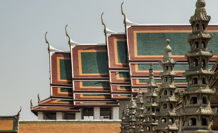 Bangkok, Thailand. Apr - 15, 2022 : Architecture exterior of the chapel with Gable apex roof and Chinese stone sculptures against blue sky at the famous Wat Suthat thepwararam buddhist temple. Selective focus.のeditorial素材