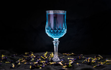 Glass of Cocktail butterfly pea or Flower anchan blue juice (Clitoria) and dry butterfly pea flowers...