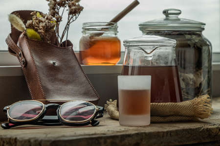 Refreshing with Chinese herbal tea (Jub Lieng) served with honey on old wooden table with city view. Herbal plant and healthy drinks concept, Selective focus.の写真素材