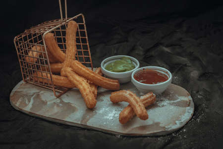 Traditional spanish churros sticks (Fried-dough pastry) Served usually with Thai pandan custard and Ketchup. Breakfast everywhere in Spain, Copy space, Selective focus.の写真素材