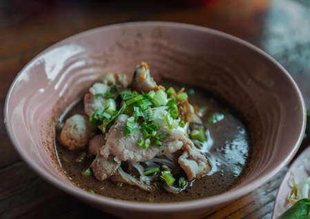 Thin rice noodles in thicken soup added blood with Pork balls, Sliced pork, pork liver sprinkle with Sliced spring onion (Nam tok small noodles). Thai Boat noodles soup or Guay tiew reua is Thailand's most famous noodles soup, Selective Focus.の写真素材