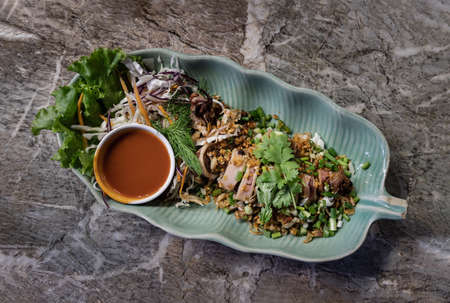 Squid stuffed with Pork mince and Garlic sprinkle with dill, corianders and spring onion served with chili sauce. Top view, Selective focus.の写真素材