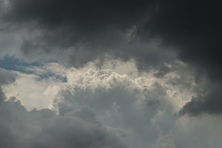 The sun shines through the clouds in the evening sky with dramatic light. The shape of the clouds...