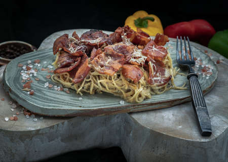 Truffle carbonara spaghetti with fried bacon and grated cheese in ceramic plate. Italian cuisine, Selective Focus.の写真素材