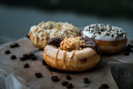 Three doughnuts covered with Choco peanut butter, Cookies and creme and Almendras on wooden cutting...