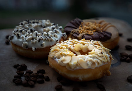 Three doughnuts covered with Almendras, Cookies and creme and Choco peanut butter on wooden cutting...