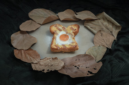 Homemade fried egg in a hole Bacon and Cheese toast on ceramic tray with dark background. Sandwiches...