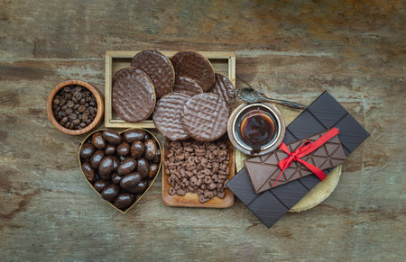 Composition of different Dark chocolate bars and pieces, Melted chocolate and Coffee beans on Old...