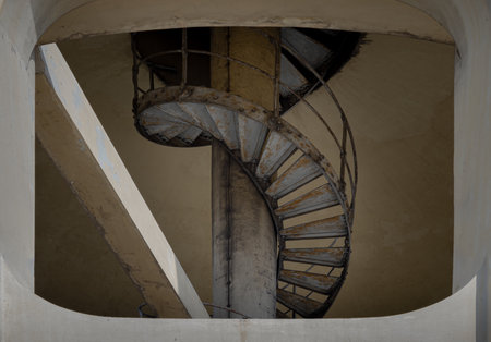 View of old metal spiral staircase inside columnar structures old water tower made of cement. Selective focus.の写真素材