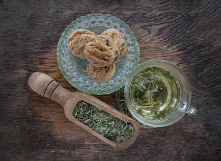 Refreshing and Enjoy with A cup of hot hemp tea (CBD herbal tea) and Dried organic hemp leaves served with Scones on old rustic wooden background. Healthy drink concept. Top view, Space for text.の写真素材