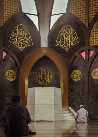 Bangkok, Thailand - May 28, 2023 - Religious muslim men sits and recite prayers for God on the floor in the Central Mosque and Islamic Center of Thailand. The religion of islam, Space for text, Selective focus.のeditorial素材