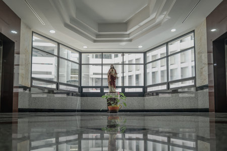 Bangkok, Thailand - 17 Jul, 2023 - Jesus Christ Statue which is on the wooden platform in front of the glass wall. You can see through the city view. The figure of Jesus Christ, Space for text, Selective focus.のeditorial素材
